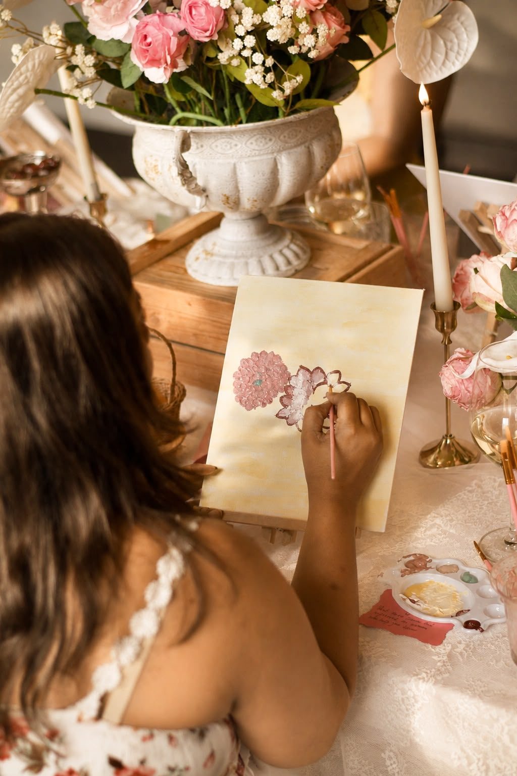 Guest painting a floral canvas, from a past Three Petals event